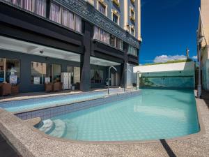 a swimming pool in front of a building at Fulidun Hotel Kenting in Hengchun