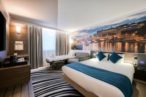 una habitación de hotel con una cama grande y un sofá en Novotel Paris Centre Bercy, en París 100 fotos más