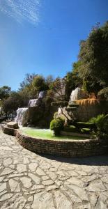 a stone path with a waterfall in a park at El Mirador del Asno in El Bosque +25 photos