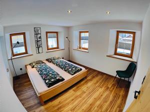 a bedroom with a bed and a chair in it at Chasa Salnuun Ferienwohnungen in Samnaun