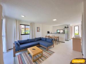 a living room with a blue couch and a table at Beachfront Duplex B por Be My Guest in Aquiraz