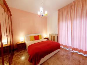 a bedroom with a red and white bed and a chandelier at Fiori e Frutti Sunshine Home in Almese