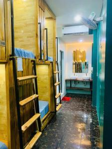 a group of bunk beds in a room with a bathroom at The Little Leaf Hostel - Restaurant & Rooptop Bar in Cat Ba