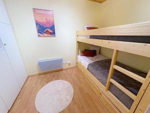 a small room with two bunk beds and a rug at Cocon moderne vue pistes - Balcon sud- télécabine 160 m in Chamrousse