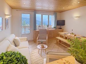 a living room with a white couch and a table at Cocon moderne vue pistes - Balcon sud- télécabine 160 m in Chamrousse