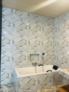 a bathroom with a white sink and a marble wall at Maleesha Homestay in Ella +118 photos
