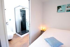 een slaapkamer met een spiegel naast een bed bij Le CapriBeach by TAH - Top emplacement & Parking in Pornichet