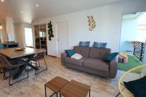 een woonkamer met een bank en een tafel bij Le CapriBeach by TAH - Top emplacement & Parking in Pornichet +14 foto's