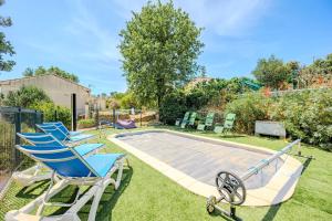 un gruppo di sedie a sdraio accanto a una piscina di Partisole - Maison Climatisée avec Piscine a Garéoult
