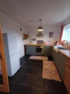 a kitchen with blue cabinets and a white refrigerator at Dog friendly holiday home Acharacle sleeps 6 in Acharacle