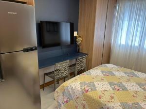 Un dormitorio con una cama y un escritorio con televisión. en Studio Barra Salvador -, en Salvador 1 foto más