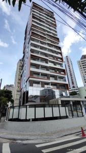 un edificio alto con una valla delante en Studio Barra Salvador -, en Salvador