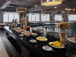 a buffet line with plates of food on a table at GUIDE HOTEL Kenting Resort in Hengchun South Gate +32 photos