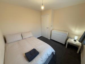 ein Schlafzimmer mit einem Bett mit einem blauen Kissen darauf in der Unterkunft Charming Aylesbury Retreat with 4 Bedrooms in Weedon + 5 Fotos