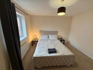 ein Schlafzimmer mit einem Bett mit einem blauen Handtuch darauf in der Unterkunft Charming Aylesbury Retreat with 4 Bedrooms in Weedon