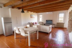 a kitchen and living room with a white table and chairs at Tetti di Parma in Parma