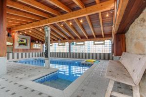 a swimming pool in a house with a wooden ceiling at Casa Clemente in Zamora