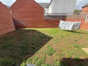 ein Hof mit einer Wäscheleine, die von einer Ziegelmauer hängt in der Unterkunft Charming Aylesbury Retreat with 4 Bedrooms in Weedon