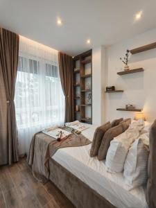 a large bed in a room with a large window at POOL RESORT Vila Lena - Lux residence apartman 1 in Vrdnik