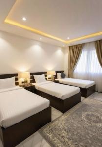 - une chambre d'hôtel avec 2 lits et un tapis dans l'établissement شقق نرمادا المفروشة 303, à Médine