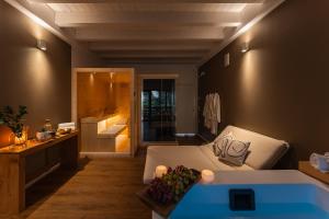 a living room with a bed and a bath tub at Appartamento con accesso a spa privata in Maso