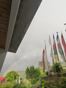 een groep vlaggen met een regenboog op de achtergrond bij Zhim khang in Sosing +2 foto's