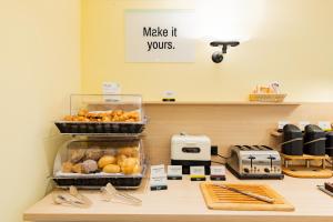 a bakery counter with pastries and a make it yours sign at Garner Hotel Cologne East by IHG in Cologne