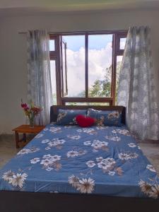 een bed met een blauw dekbed en een raam bij Zhim khang in Sosing