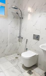 une salle de bains blanche avec toilettes et lavabo dans l'établissement شقق نرمادا المفروشة 303, à Médine