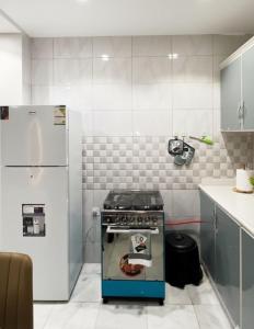 une cuisine avec une cuisinière et un réfrigérateur dans l'établissement شقق نرمادا المفروشة 303, à Médine