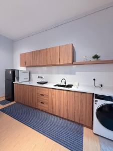 een keuken met een spoelbak en een koelkast bij Suithauz Studio in Kuantan