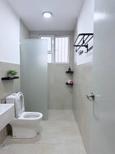 een witte badkamer met een toilet en een wastafel bij Suithauz Studio in Kuantan