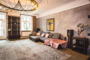 a living room with a couch and a chandelier at Riga Lux Apartments - Skolas in Rīga