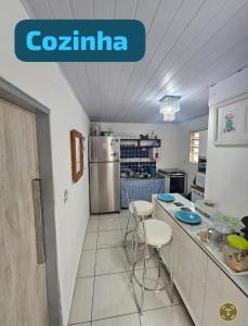 a kitchen with a counter with stools and a refrigerator at Junior aclimação in Sao Paulo