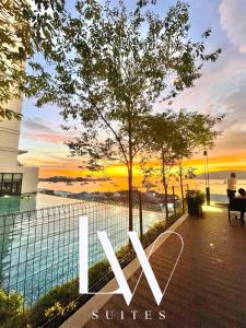 a sign that says sun suites with a sunset in the background at The Shore Kota Kinabalu City Centre by LW Suites in Kota Kinabalu