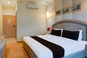 a bedroom with a large bed in a hotel room at Townhouse Oak Sahastradhara Road Dehradun in Dehradun