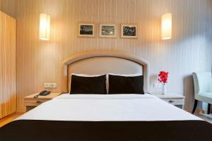 a bedroom with a large white bed and a chair at Townhouse Oak Sahastradhara Road Dehradun in Dehradun