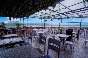 a restaurant with tables and chairs with a view at Townhouse Oak Sahastradhara Road Dehradun in Dehradun