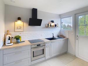 a kitchen with white cabinets and a sink at NUIT ET JOUR à Chaumont in Chaumont +18 photos