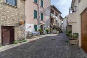 un callejón en un edificio con mesa y sillas en RaBi Rooms - Rafting & Bike Rooms, en Valbrenta 