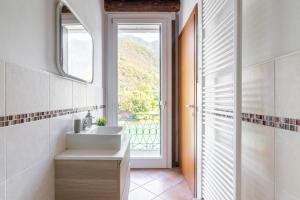 Un baño con lavabo y ventana. en RaBi Rooms - Rafting & Bike Rooms, en Valbrenta 