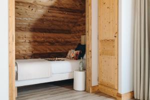 a bed in a room with a wooden wall at Hôtel des 2 Gares in Saint-Gervais-les-Bains