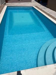a large blue swimming pool with blue water at Holiday Villa with Private Pool - Villa Farol in Nazaré