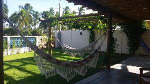 a hammock under a pergola in a yard at Bangalô Patacho in Pôrto de Pedras