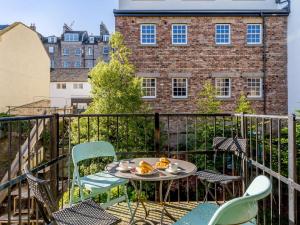 un tavolo e delle sedie su un balcone con un edificio di 3 Bed in Edinburgh 79008 a Edimburgo