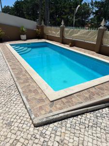 a swimming pool with blue water in a backyard at Holiday Villa with Private Pool - Villa Farol in Nazaré +42 photos