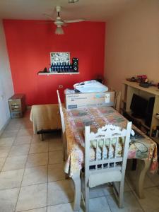 ein Esszimmer mit einem Tisch und einer roten Wand in der Unterkunft Santiago del estero in Santiago del Estero