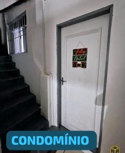 a white door with a sign on it next to a staircase at Junior aclimação in Sao Paulo