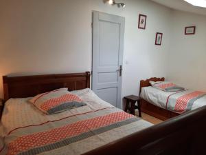 a bedroom with two beds and a door at L'ammonite in Chaunay