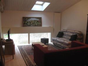 a living room with a couch and a window at L'ammonite in Chaunay